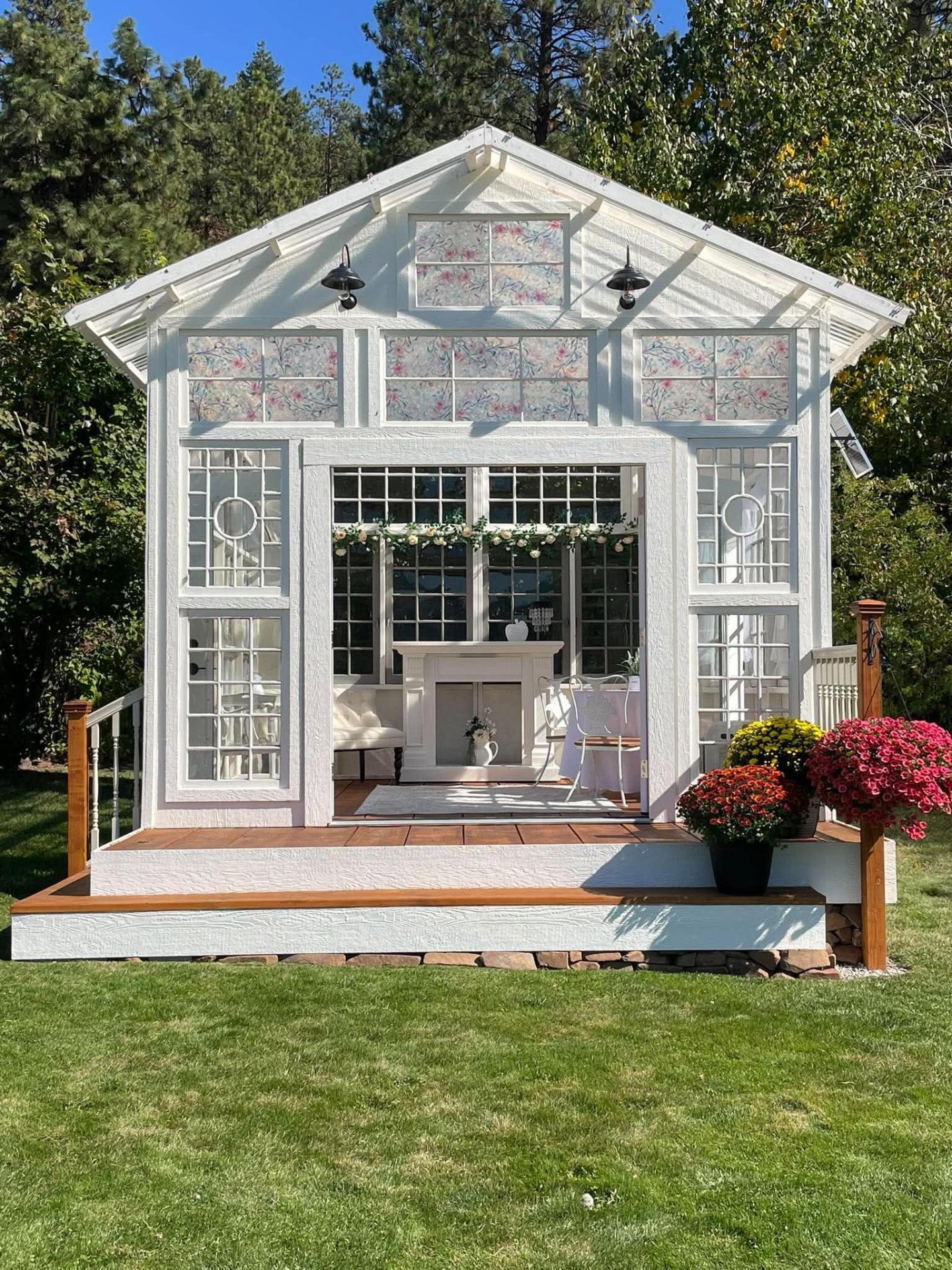 The restored Glasshouse at Mountain Pines Meadow, framed by pines and gardens