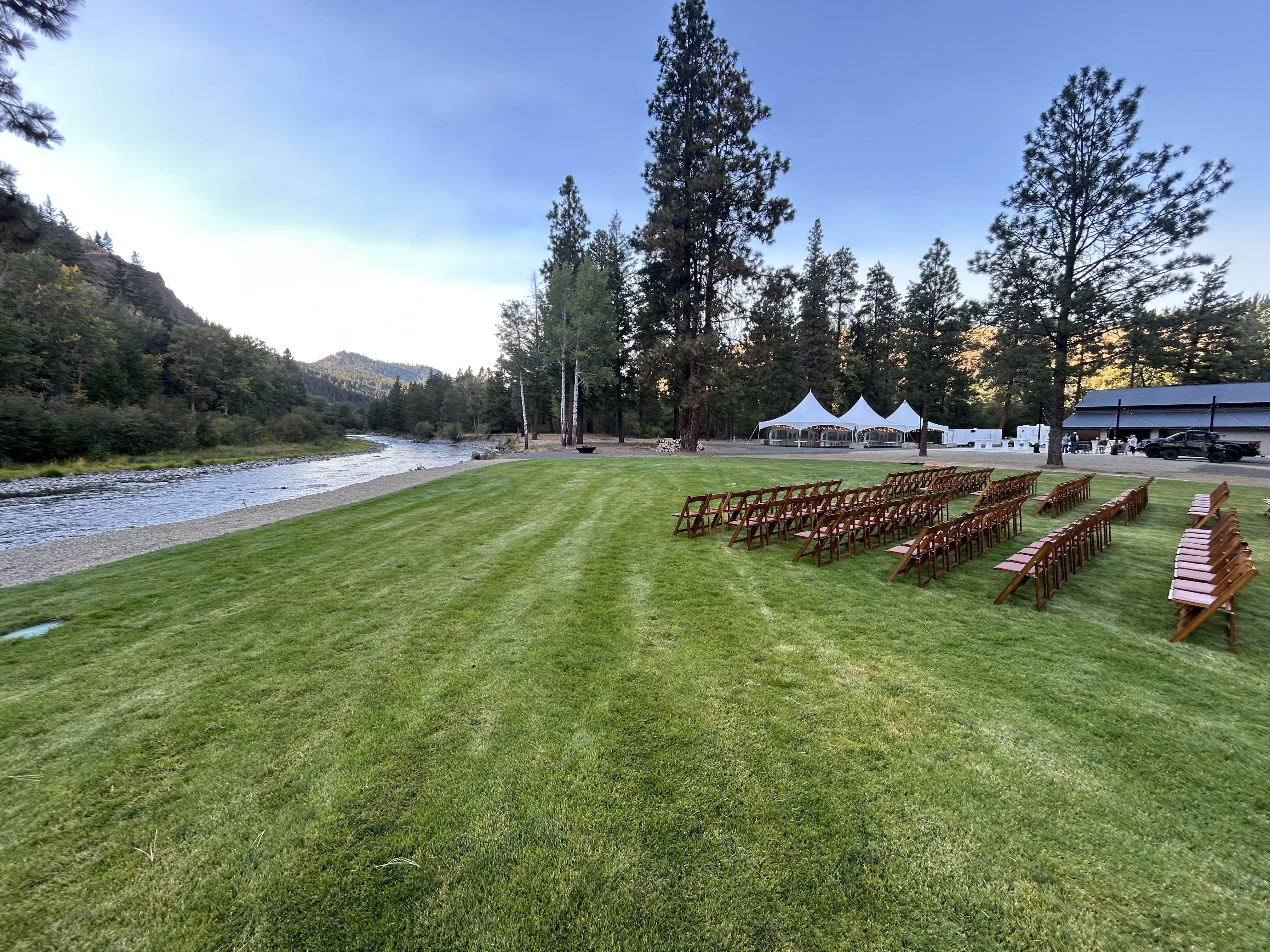 Outdoor wedding setup with rental tables, chairs, and tent in the Yakima River area