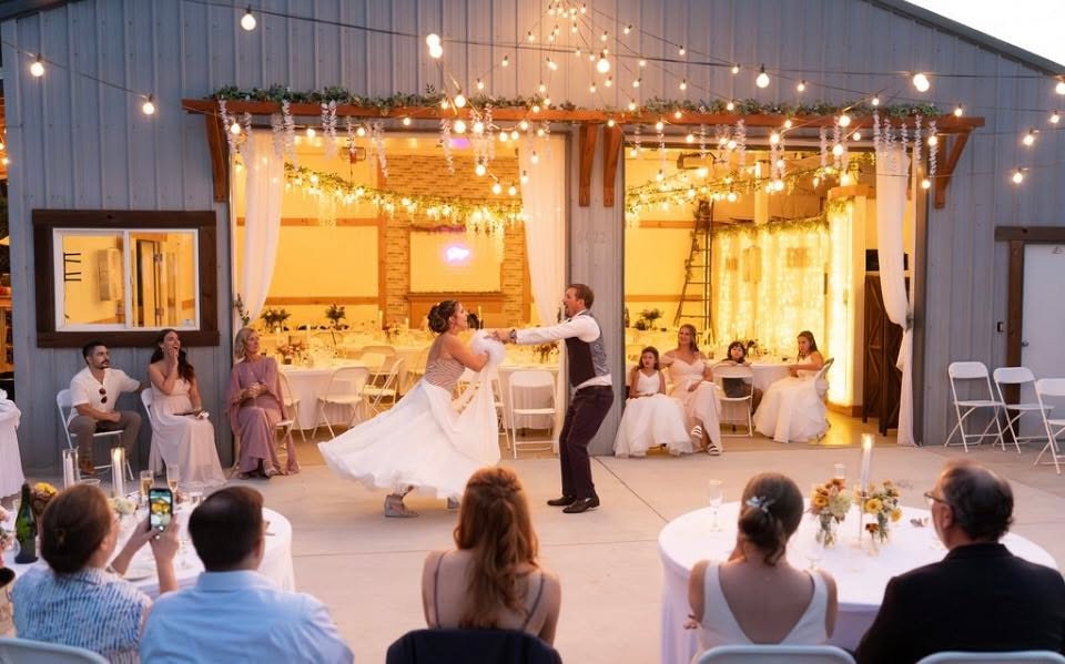 Newlyweds sharing their first dance outside the Celebration Hall at Mountain Pines Meadow